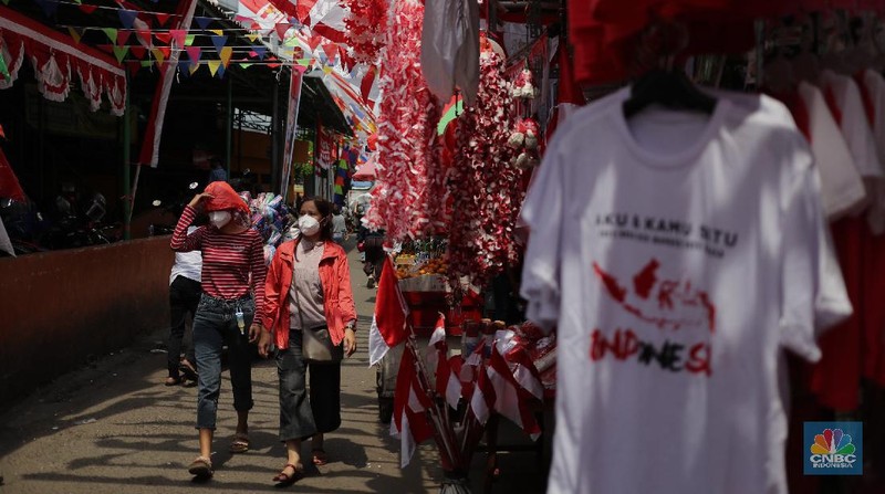 Pedagang memasang pernak pernik bendera di kawasan Pasar Kramat Jati, Jakarta, Senin (9/8/2021). Pedagang mengeluhkan sepinya pembeli, momentum Hari Kemerdekaan RI seharusnya menjadi ladang rezeki dari menjual pernak pernik hiasan bendera merah putih. 
Sahir (25) menjual pernak-pernik bendera sejak tahun 2013 ini mengatakan 