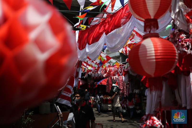 Pedagang memasang pernak pernik bendera di kawasan Pasar Kramat Jati, Jakarta, Senin (9/8/2021). Pedagang mengeluhkan sepinya pembeli, momentum Hari Kemerdekaan RI seharusnya menjadi ladang rezeki dari menjual pernak pernik hiasan bendera merah putih. 
Sahir (25) menjual pernak-pernik bendera sejak tahun 2013 ini mengatakan 