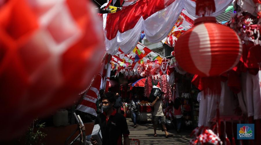 Pedagang memasang pernak pernik bendera di kawasan Pasar Kramat Jati, Jakarta, Senin (9/8/2021). Pedagang mengeluhkan sepinya pembeli, momentum Hari Kemerdekaan RI seharusnya menjadi ladang rezeki dari menjual pernak pernik hiasan bendera merah putih. 
Sahir (25) menjual pernak-pernik bendera sejak tahun 2013 ini mengatakan 