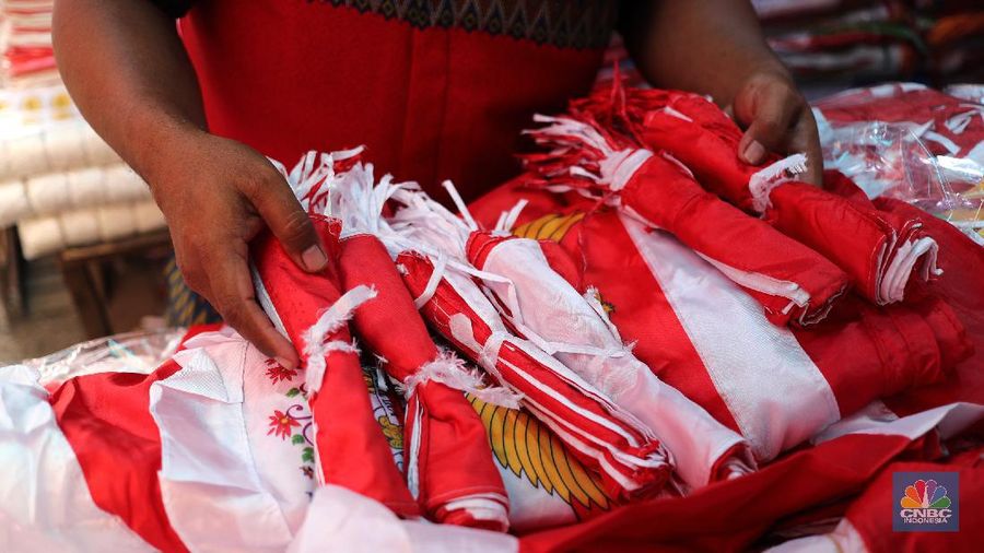 Pedagang memasang pernak pernik bendera di kawasan Pasar Kramat Jati, Jakarta, Senin (9/8/2021). Pedagang mengeluhkan sepinya pembeli, momentum Hari Kemerdekaan RI seharusnya menjadi ladang rezeki dari menjual pernak pernik hiasan bendera merah putih. 
Sahir (25) menjual pernak-pernik bendera sejak tahun 2013 ini mengatakan 