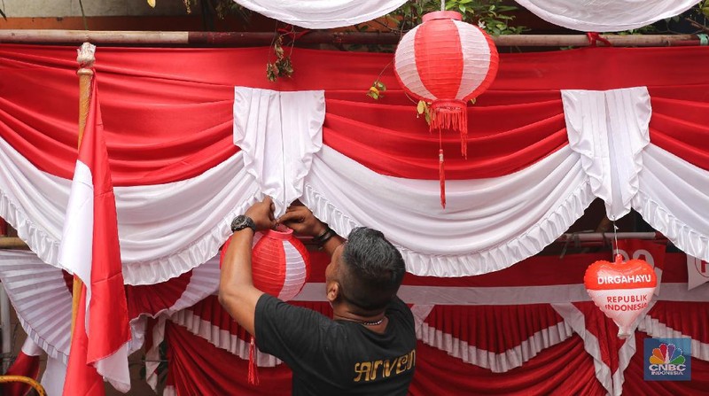 Pedagang memasang pernak pernik bendera di kawasan Pasar Kramat Jati, Jakarta, Senin (9/8/2021). Pedagang mengeluhkan sepinya pembeli, momentum Hari Kemerdekaan RI seharusnya menjadi ladang rezeki dari menjual pernak pernik hiasan bendera merah putih. 
Sahir (25) menjual pernak-pernik bendera sejak tahun 2013 ini mengatakan 