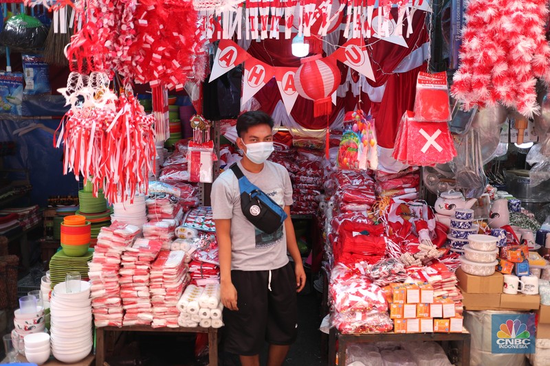 Pedagang memasang pernak pernik bendera di kawasan Pasar Kramat Jati, Jakarta, Senin (9/8/2021). Pedagang mengeluhkan sepinya pembeli, momentum Hari Kemerdekaan RI seharusnya menjadi ladang rezeki dari menjual pernak pernik hiasan bendera merah putih. 
Sahir (25) menjual pernak-pernik bendera sejak tahun 2013 ini mengatakan 