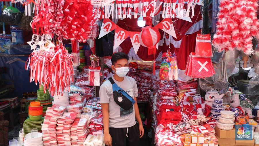 Pedagang memasang pernak pernik bendera di kawasan Pasar Kramat Jati, Jakarta, Senin (9/8/2021). Pedagang mengeluhkan sepinya pembeli, momentum Hari Kemerdekaan RI seharusnya menjadi ladang rezeki dari menjual pernak pernik hiasan bendera merah putih. 
Sahir (25) menjual pernak-pernik bendera sejak tahun 2013 ini mengatakan 