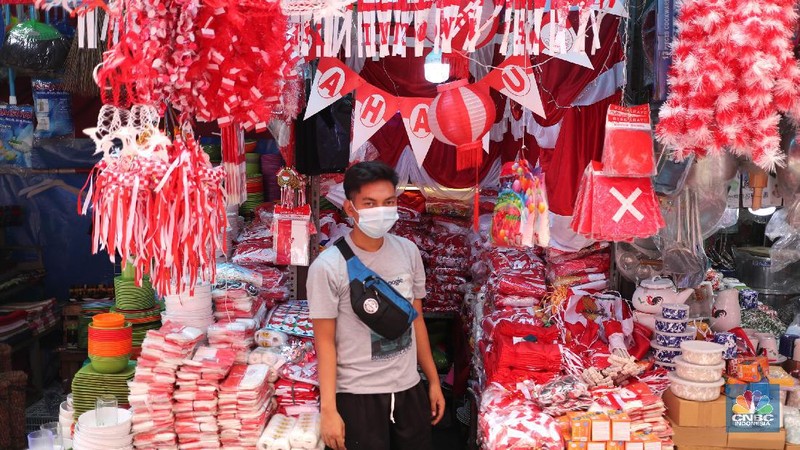 Pedagang memasang pernak pernik bendera di kawasan Pasar Kramat Jati, Jakarta, Senin (9/8/2021). Pedagang mengeluhkan sepinya pembeli, momentum Hari Kemerdekaan RI seharusnya menjadi ladang rezeki dari menjual pernak pernik hiasan bendera merah putih. 
Sahir (25) menjual pernak-pernik bendera sejak tahun 2013 ini mengatakan 