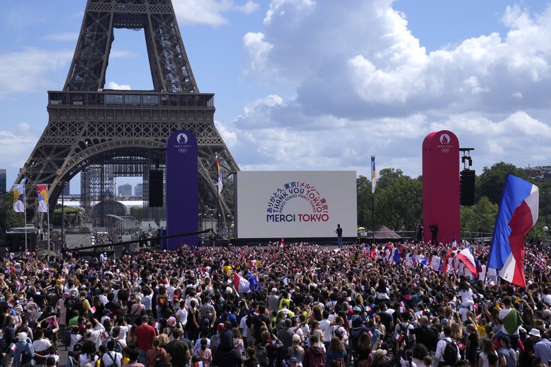 Pesta Tuan Rumah Olimpiade 2024 di Paris, Prancis Spectators gather at the Olympics fan zone in the Trocadero Gardens in front of the Eiffel Tower in Paris, Sunday, Aug. 8, 2021. Celebrations were held in Paris Sunday as part of the handover ceremony of Tokyo 2020 to Paris 2024, as Paris will be the next Summer Games host in 2024. The passing of the hosting baton will be split between the Olympic Stadium in Tokyo and a public party and concert in Paris. (AP Photo/Francois Mori)