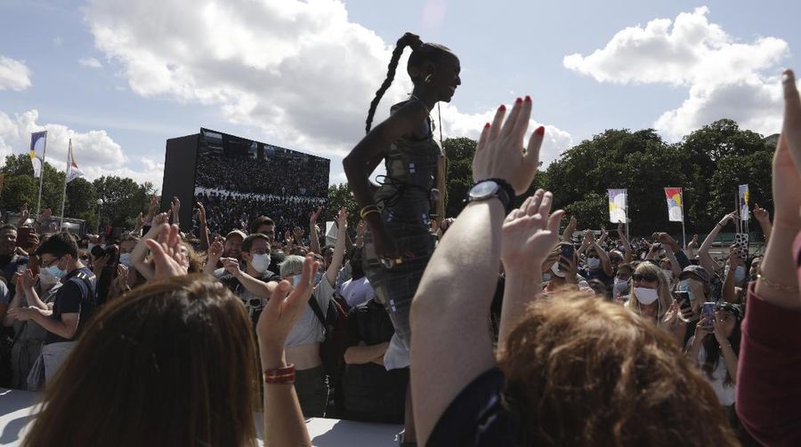 Spectators gather at the Olympics fan zone in the Trocadero Gardens in front of the Eiffel Tower in Paris, Sunday, Aug. 8, 2021. Celebrations were held in Paris Sunday as part of the handover ceremony of Tokyo 2020 to Paris 2024, as Paris will be the next Summer Games host in 2024. The passing of the hosting baton will be split between the Olympic Stadium in Tokyo and a public party and concert in Paris. (AP Photo/Francois Mori)