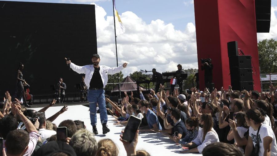 Spectators gather at the Olympics fan zone in the Trocadero Gardens in front of the Eiffel Tower in Paris, Sunday, Aug. 8, 2021. Celebrations were held in Paris Sunday as part of the handover ceremony of Tokyo 2020 to Paris 2024, as Paris will be the next Summer Games host in 2024. The passing of the hosting baton will be split between the Olympic Stadium in Tokyo and a public party and concert in Paris. (AP Photo/Francois Mori)