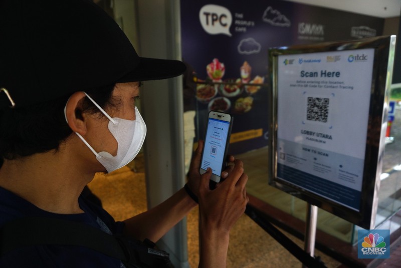Petugas memberikan informasi scan code vaksin kepada pengunjung yang akan masuk ke dalam Mal Blok M Plaza, Jakarta, Selasa (10/8/2021). Pemerintah mengumumkan kembali memperpanjang PPKM hingga 16 Agustus 2021. Dalam perpanjangan kali ini pusat perbelanjaan atau mal di wilayah PPKM level 4 bisa dibuka dalam kapasitas 25%.  (CNBC Indonesia/ Tri Susilo)