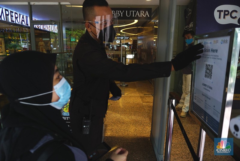 Suasana hari pertama pembukaan kembali mall saat perpanjangan PPKM level 4 di Blok M Plaza, Jakarta, Selasa (10/8/2021). Petugas memberikan informasi scan code vaksin kepada pengunjung yang akan masuk ke dalam Mal Blok M Plaza, Jakarta, Selasa (10/8/2021). Pemerintah mengumumkan kembali memperpanjang PPKM hingga 16 Agustus 2021. Dalam perpanjangan kali ini pusat perbelanjaan atau mal di wilayah PPKM level 4 bisa dibuka dalam kapasitas 25%. (CNBC Indonesia/ Tri Susilo)