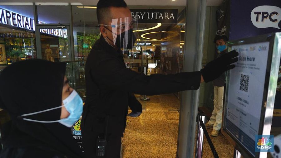 Petugas memberikan informasi scan code vaksin kepada pengunjung yang akan masuk ke dalam Mal Blok M Plaza, Jakarta, Selasa (10/8/2021). Pemerintah mengumumkan kembali memperpanjang PPKM hingga 16 Agustus 2021. Dalam perpanjangan kali ini pusat perbelanjaan atau mal di wilayah PPKM level 4 bisa dibuka dalam kapasitas 25%.  (CNBC Indonesia/ Tri Susilo)