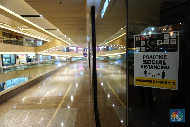 Suasana hari pertama pembukaan kembali mall saat perpanjangan PPKM level 4 di Blok M Plaza, Jakarta, Selasa (10/8/2021). Petugas memberikan informasi scan code vaksin kepada pengunjung yang akan masuk ke dalam Mal Blok M Plaza, Jakarta, Selasa (10/8/2021). Pemerintah mengumumkan kembali memperpanjang PPKM hingga 16 Agustus 2021. Dalam perpanjangan kali ini pusat perbelanjaan atau mal di wilayah PPKM level 4 bisa dibuka dalam kapasitas 25%. (CNBC Indonesia/ Tri Susilo)