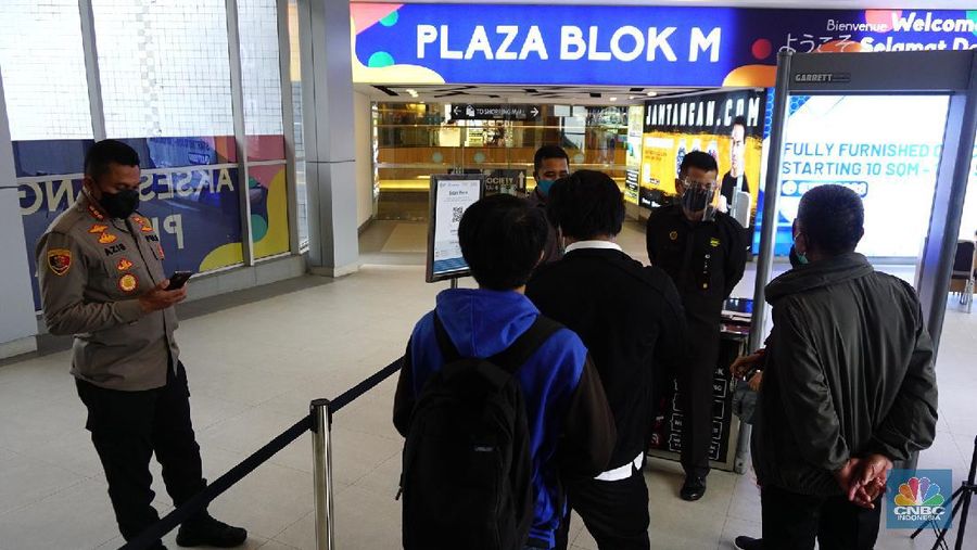 Petugas memberikan informasi scan code vaksin kepada pengunjung yang akan masuk ke dalam Mal Blok M Plaza, Jakarta, Selasa (10/8/2021). Pemerintah mengumumkan kembali memperpanjang PPKM hingga 16 Agustus 2021. Dalam perpanjangan kali ini pusat perbelanjaan atau mal di wilayah PPKM level 4 bisa dibuka dalam kapasitas 25%.  (CNBC Indonesia/ Tri Susilo)