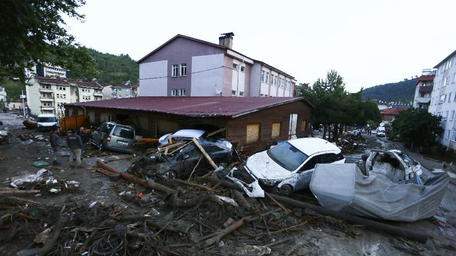 Destroyed cars in a street after floods and mudslides in Bozkurt town of Kastamonu province, Thursday, Aug. 12, 2021. The floods triggered by torrential rains battered the Black Sea coastal provinces of Bartin, Kastamonu, Sinop and Samsun on Wednesday, demolishing homes and bridges and sweeping cars away by torrents. Helicopters scrambled to rescue people stranded on rooftops.(IHA via AP)