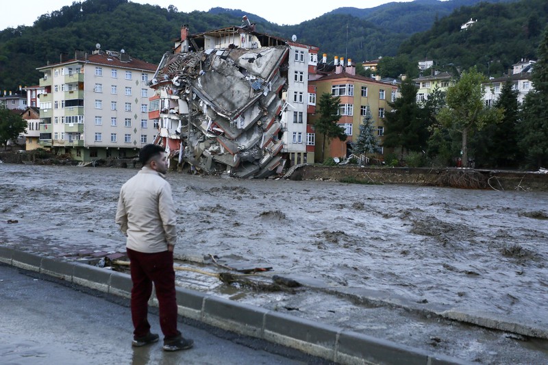 Destroyed cars in a street after floods and mudslides in Bozkurt town of Kastamonu province, Thursday, Aug. 12, 2021. The floods triggered by torrential rains battered the Black Sea coastal provinces of Bartin, Kastamonu, Sinop and Samsun on Wednesday, demolishing homes and bridges and sweeping cars away by torrents. Helicopters scrambled to rescue people stranded on rooftops.(IHA via AP)