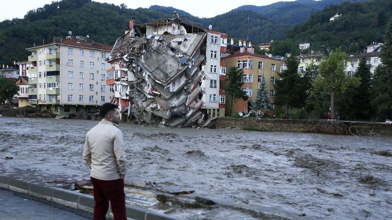Destroyed cars in a street after floods and mudslides in Bozkurt town of Kastamonu province, Thursday, Aug. 12, 2021. The floods triggered by torrential rains battered the Black Sea coastal provinces of Bartin, Kastamonu, Sinop and Samsun on Wednesday, demolishing homes and bridges and sweeping cars away by torrents. Helicopters scrambled to rescue people stranded on rooftops.(IHA via AP)