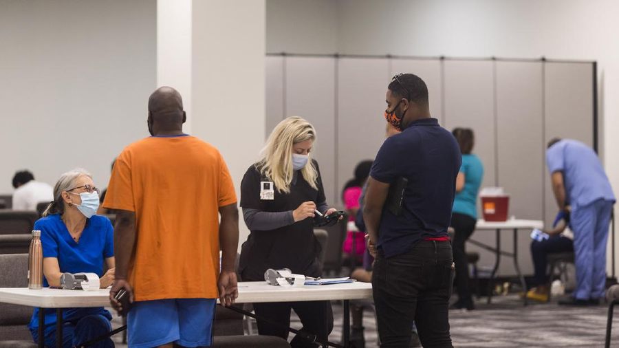 In this photo provided by Impact Church, people register for a COVID-19 vaccination at an event held by Impact Church on Aug. 8, 2021, in Jacksonville, Fla. The church has lost seven members in the last few weeks, Pastor George Davis said Wednesday, Aug. 11. (Impact Church via AP)