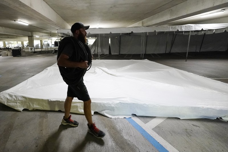 Jay McCullough of Mississippi Tent, arranges tent poles onto a 