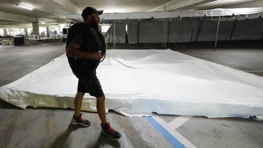 Jay McCullough of Mississippi Tent, arranges tent poles onto a 