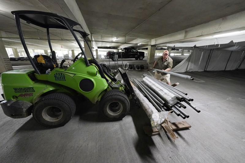 Jay McCullough of Mississippi Tent, arranges tent poles onto a 
