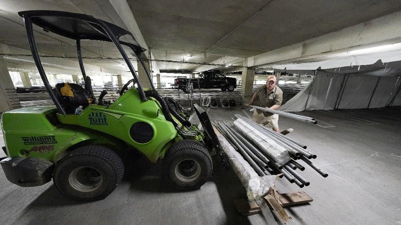 Jay McCullough of Mississippi Tent, arranges tent poles onto a 