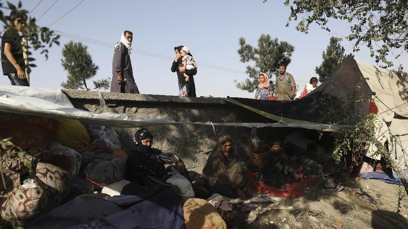 Internally displaced Afghans from northern provinces, who fled their home due to fighting between the Taliban and Afghan security personnel, take refuge in a public park Kabul, Afghanistan, Friday, Aug. 13, 2021. The Taliban have completed their sweep of the country's south on Friday, as they took four more provincial capitals in a lightning offensive that is gradually encircling Kabul, just weeks before the U.S. is set to officially end its two-decade war. (AP Photo/Rahmat Gul)