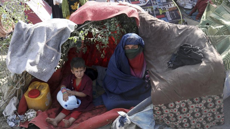 Internally displaced Afghans from northern provinces, who fled their home due to fighting between the Taliban and Afghan security personnel, take refuge in a public park Kabul, Afghanistan, Friday, Aug. 13, 2021. The Taliban have completed their sweep of the country's south on Friday, as they took four more provincial capitals in a lightning offensive that is gradually encircling Kabul, just weeks before the U.S. is set to officially end its two-decade war. (AP Photo/Rahmat Gul)