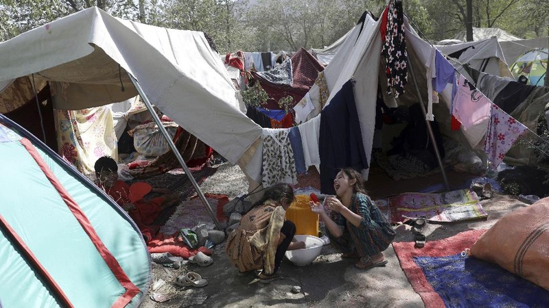 Internally displaced Afghans from northern provinces, who fled their home due to fighting between the Taliban and Afghan security personnel, take refuge in a public park Kabul, Afghanistan, Friday, Aug. 13, 2021. The Taliban have completed their sweep of the country's south on Friday, as they took four more provincial capitals in a lightning offensive that is gradually encircling Kabul, just weeks before the U.S. is set to officially end its two-decade war. (AP Photo/Rahmat Gul)