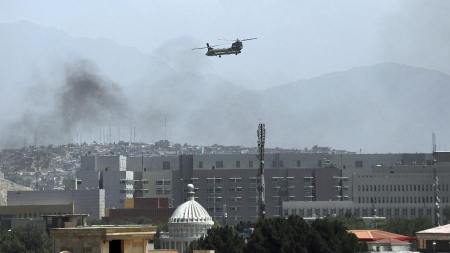 A U.S. Chinook helicopter flies over the city of Kabul, Afghanistan, Sunday, Aug. 15, 2021. Taliban fighters entered the outskirts of the Afghan capital on Sunday, further tightening their grip on the country as panicked workers fled government offices and helicopters landed at the U.S. Embassy. (AP Photo/Rahmat Gul)