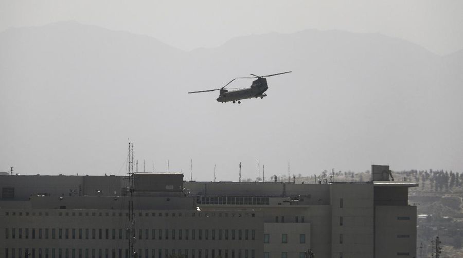 A U.S. Chinook helicopter flies over the U.S. Embassy in Kabul, Afghanistan, Sunday, Aug. 15, 2021. Helicopters are landing at the U.S. Embassy in Kabul as diplomatic vehicles leave the compound amid the Taliban advanced on the Afghan capital. (AP Photo/Rahmat Gul)
