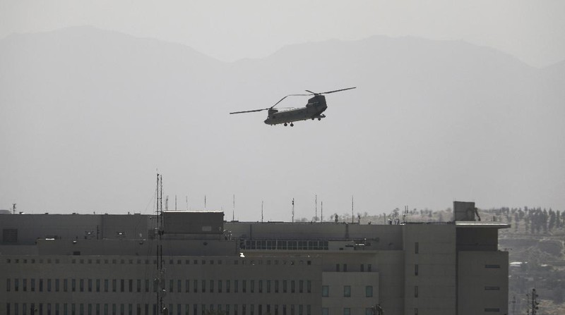 Anti-missile decoy flares are deployed as U.S. Black Hawk military helicopters and a dirigible balloon fly over the city of Kabul, Afghanistan, Sunday, Aug. 15, 2021. Taliban fighters entered the outskirts of the Afghan capital on Sunday and said they were awaiting a “peaceful transfer” of the city after promising not to take it by force, but amid the uncertainty panicked workers fled government offices and helicopters landed at the U.S. Embassy. (AP Photo/Rahmat Gul)