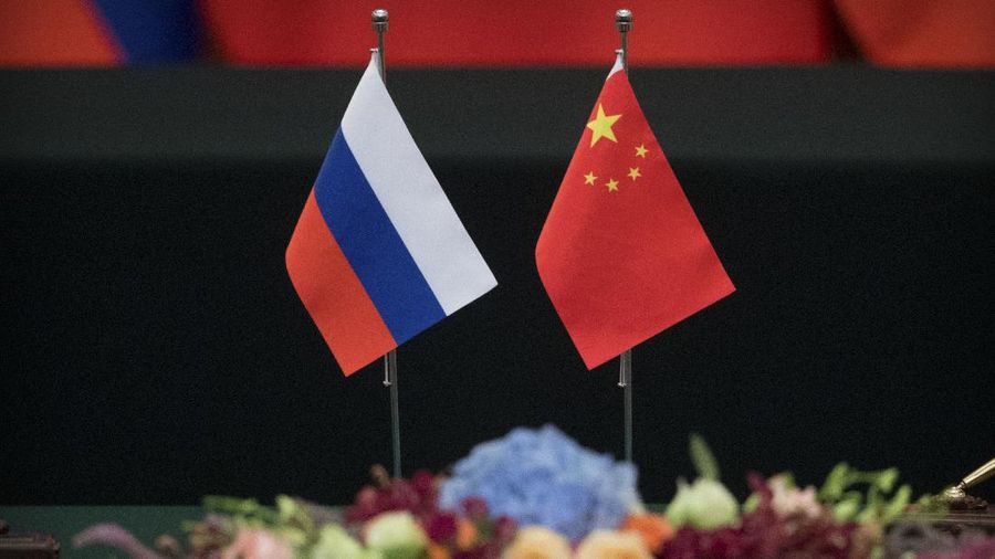 Russian, left, and Chinese flags sit on a table before a signing ceremony at the Great Hall of the People in Beijing, Friday, June 8, 2018. Cooperation between Russia and China is at an all-time high, Russian President Vladimir Putin told his Chinese counterpart, Xi Jinping, in a meeting Friday ahead of a summit featuring their two countries and six Asian states. (AP Photo/Mark Schiefelbein)