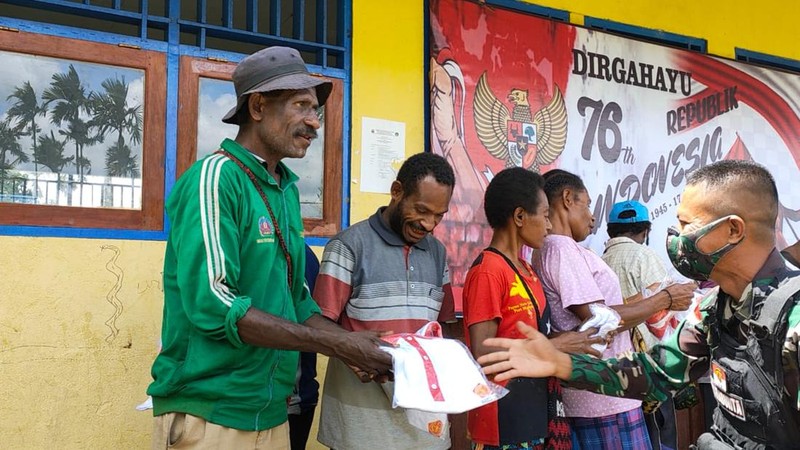 Dalam rangka menyambut HUT RI ke-76, Satgas Pamtas RI-PNG Yonif Mekanis 512/QY membagikan dan memasang bendera merah putih di kampung-kampung serta membagikan kaos merah putih kepada Warga binaan yang ada di wilayah Kabupaten Keerom Papua.  (Satgas Yonif 512/QY)