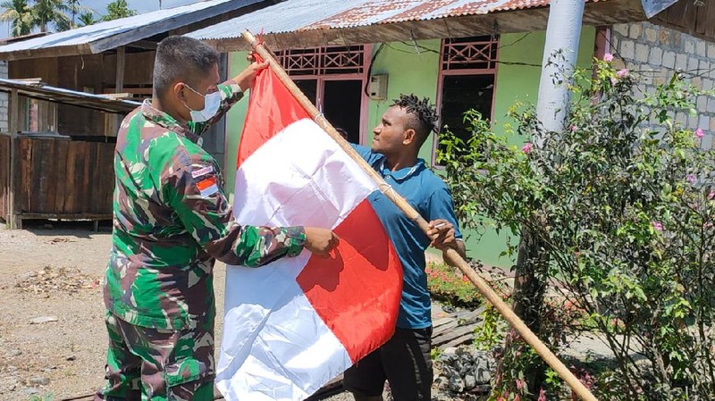 Dalam rangka menyambut HUT RI ke-76, Satgas Pamtas RI-PNG Yonif Mekanis 512/QY membagikan dan memasang bendera merah putih di kampung-kampung serta membagikan kaos merah putih kepada Warga binaan yang ada di wilayah Kabupaten Keerom Papua.  (Satgas Yonif 512/QY)