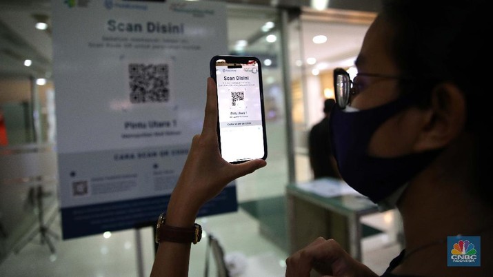 Pengunjung melakukan scanning sebelum masuk mall di Metropolitan Mall Bekasi, Jawa Barat, Rabu (18/8/2021). (CNBC Indonesia/Muhammad Sabki)