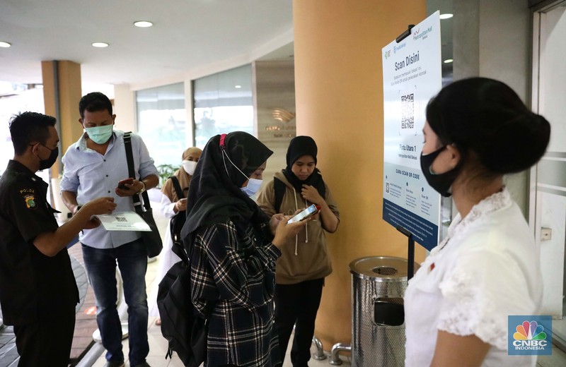 Pengunjung melakukan scanning sebelum masuk mall di Metropolitan Mall Bekasi, Jawa Barat, Rabu (18/8/2021). (CNBC Indonesia/Muhammad Sabki)