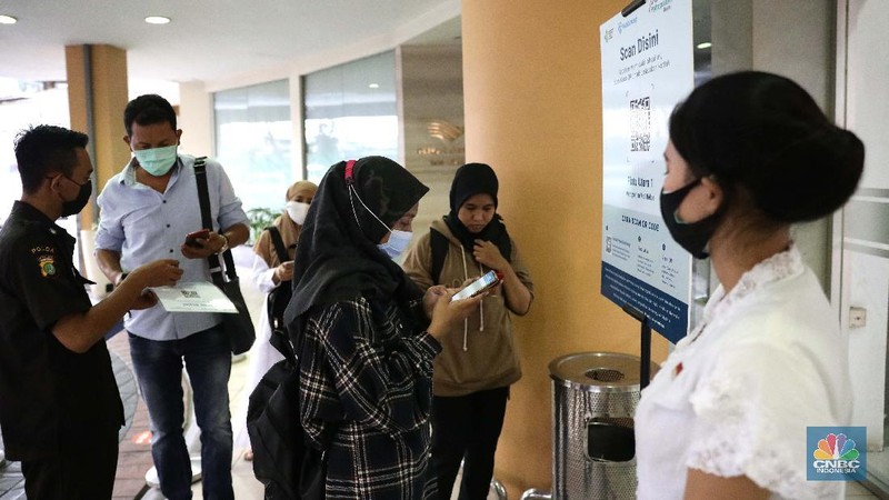 Pengunjung melakukan scanning sebelum masuk mall di Metropolitan Mall Bekasi, Jawa Barat, Rabu (18/8/2021). (CNBC Indonesia/Muhammad Sabki)