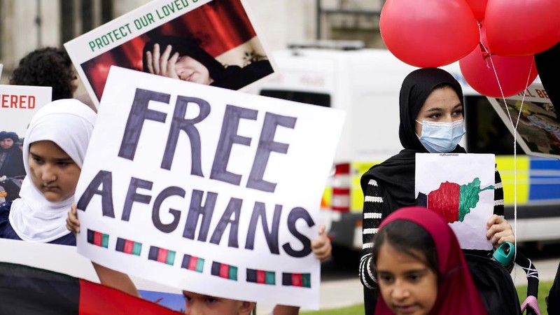 Demonstran memegang bendera Afghanistan, selama protes di Parliament Square, London, Rabu, 18 Agustus 2021. Pemerintah Inggris mengatakan pihaknya berencana untuk menerima 5.000 pengungsi Afghanistan tahun ini, terutama wanita dan anak-anak, sebagai tanggapan atas perebutan kekuasaan oleh Taliban. (AP Photo/Alberto Pezzali)