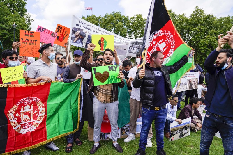 Demonstran memegang bendera Afghanistan, selama protes di Parliament Square, London, Rabu, 18 Agustus 2021. Pemerintah Inggris mengatakan pihaknya berencana untuk menerima 5.000 pengungsi Afghanistan tahun ini, terutama wanita dan anak-anak, sebagai tanggapan atas perebutan kekuasaan oleh Taliban. (AP Photo/Alberto Pezzali) Demonstran memegang bendera Afghanistan, selama protes di Parliament Square, London, Rabu, 18 Agustus 2021. Pemerintah Inggris mengatakan pihaknya berencana untuk menerima 5.000 pengungsi Afghanistan tahun ini, terutama wanita dan anak-anak, sebagai tanggapan atas perebutan kekuasaan oleh Taliban. (AP Photo/Alberto Pezzali)