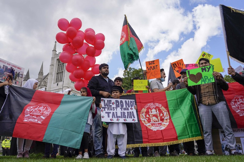 Demonstran memegang bendera Afghanistan, selama protes di Parliament Square, London, Rabu, 18 Agustus 2021. Pemerintah Inggris mengatakan pihaknya berencana untuk menerima 5.000 pengungsi Afghanistan tahun ini, terutama wanita dan anak-anak, sebagai tanggapan atas perebutan kekuasaan oleh Taliban. (AP Photo/Alberto Pezzali)