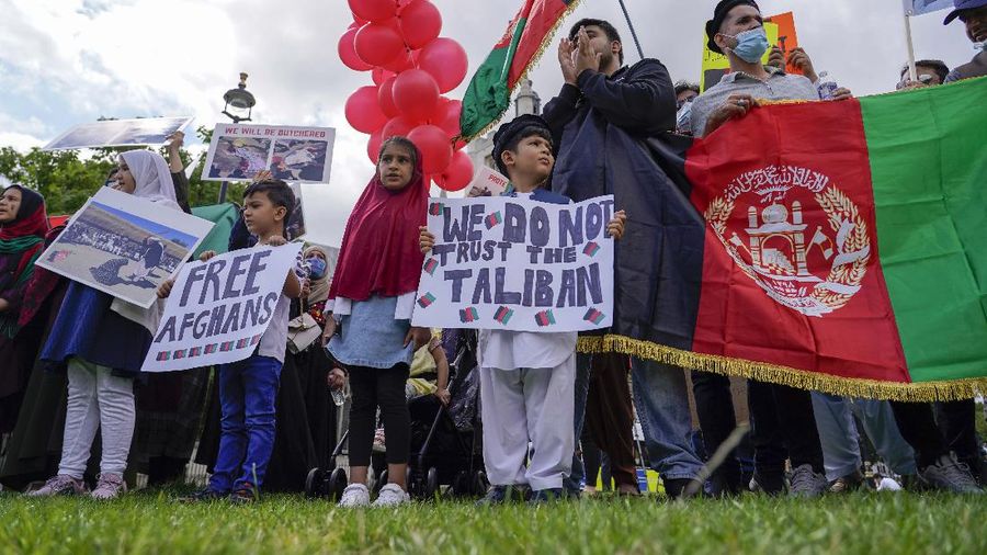 Demonstran memegang bendera Afghanistan, selama protes di Parliament Square, London, Rabu, 18 Agustus 2021. Pemerintah Inggris mengatakan pihaknya berencana untuk menerima 5.000 pengungsi Afghanistan tahun ini, terutama wanita dan anak-anak, sebagai tanggapan atas perebutan kekuasaan oleh Taliban. (AP Photo/Alberto Pezzali)