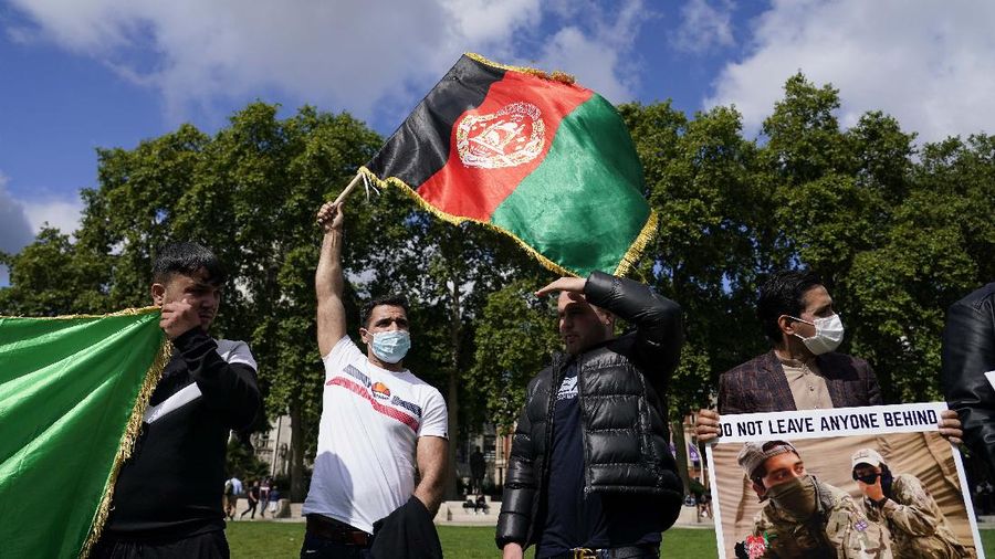 Demonstran memegang bendera Afghanistan, selama protes di Parliament Square, London, Rabu, 18 Agustus 2021. Pemerintah Inggris mengatakan pihaknya berencana untuk menerima 5.000 pengungsi Afghanistan tahun ini, terutama wanita dan anak-anak, sebagai tanggapan atas perebutan kekuasaan oleh Taliban. (AP Photo/Alberto Pezzali)