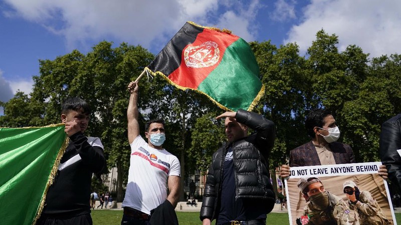 Demonstran memegang bendera Afghanistan, selama protes di Parliament Square, London, Rabu, 18 Agustus 2021. Pemerintah Inggris mengatakan pihaknya berencana untuk menerima 5.000 pengungsi Afghanistan tahun ini, terutama wanita dan anak-anak, sebagai tanggapan atas perebutan kekuasaan oleh Taliban. (AP Photo/Alberto Pezzali)