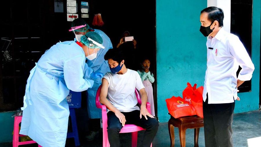 Presiden Joko Widodo meninjau program vaksinasi Covid-19 untuk masyarakat secara pintu ke pintu yang dilaksanakan di Gang Kampung Pesilat, Kecamatan Mejayan, Kabupaten Madiun, Jawa Timur, pada Kamis, 19 Agustus 2021. (Dok: Biro Pers Sekretariat Presiden)