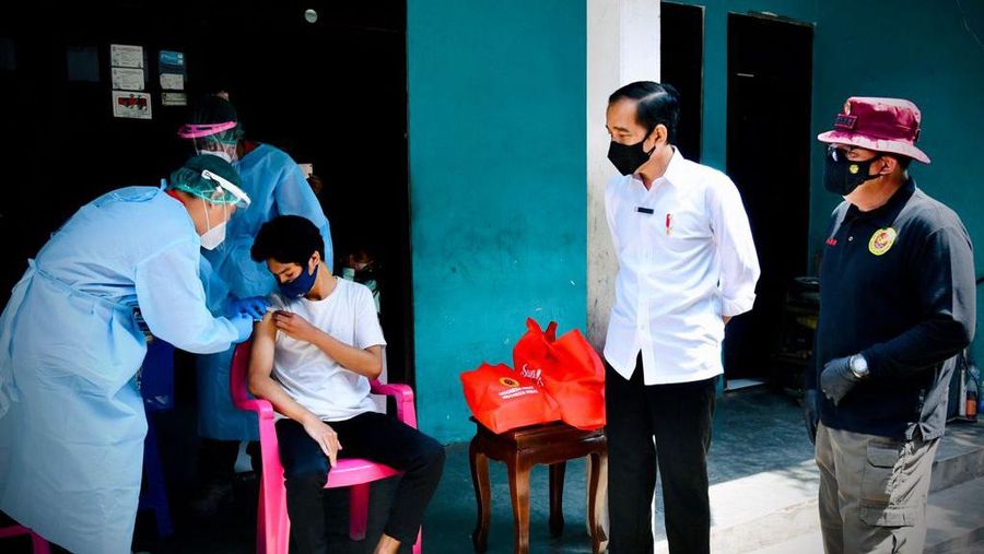 Presiden Joko Widodo meninjau program vaksinasi Covid-19 untuk masyarakat secara pintu ke pintu yang dilaksanakan di Gang Kampung Pesilat, Kecamatan Mejayan, Kabupaten Madiun, Jawa Timur, pada Kamis, 19 Agustus 2021. (Dok: Biro Pers Sekretariat Presiden)
