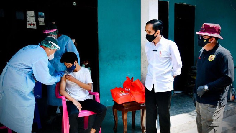 Presiden Joko Widodo meninjau program vaksinasi Covid-19 untuk masyarakat secara pintu ke pintu yang dilaksanakan di Gang Kampung Pesilat, Kecamatan Mejayan, Kabupaten Madiun, Jawa Timur, pada Kamis, 19 Agustus 2021. (Dok: Biro Pers Sekretariat Presiden)