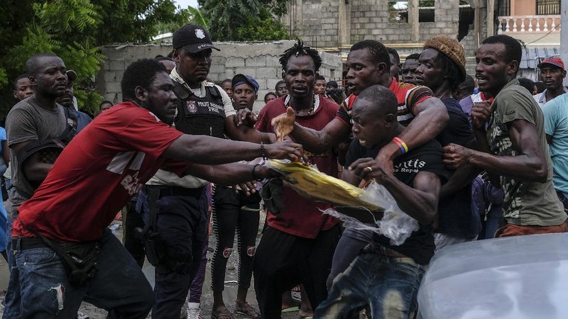 Korban gempa Haiti berebut sembako saat bantuan datang. (AP/Fernando Llano)