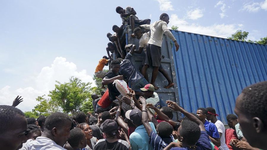 Korban gempa Haiti berebut sembako saat bantuan datang. (AP/Fernando Llano)