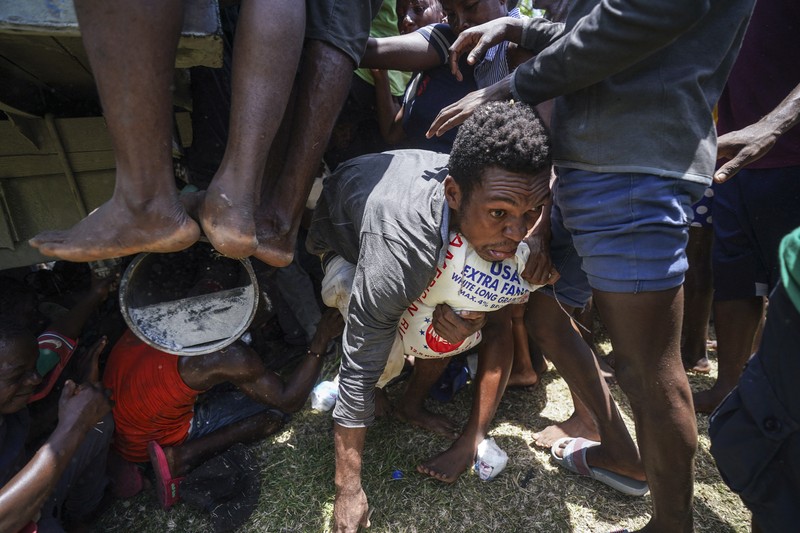 Korban gempa Haiti berebut sembako saat bantuan datang. (AP/Fernando Llano)