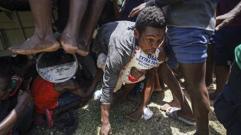 Korban gempa Haiti berebut sembako saat bantuan datang. (AP/Fernando Llano)