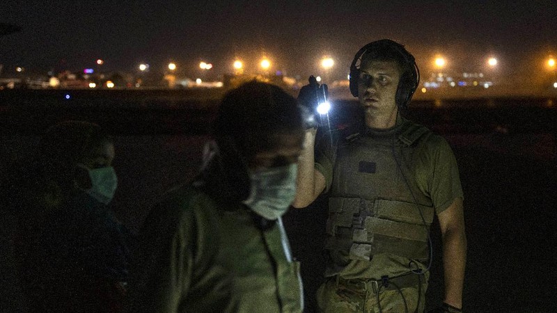 In this Aug. 20, 2021, photo provided by the U.S. Marine Corps, U.S. Marines and Norweigian coalition forces assist with security at an Evacuation Control Checkpoint ensuring evacuees are processed safely during an evacuation at Hamid Karzai International Airport in Kabul, Afghanistan. (Staff Sgt. Victor Mancilla/U.S. Marine Corps via AP)